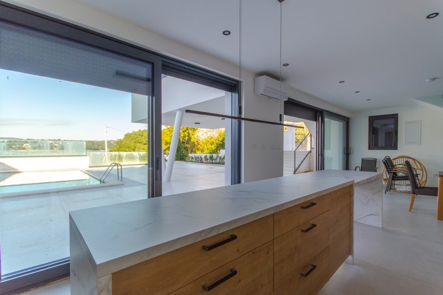Nyitott konyha, kilátással az ingatlan medencéjére.
