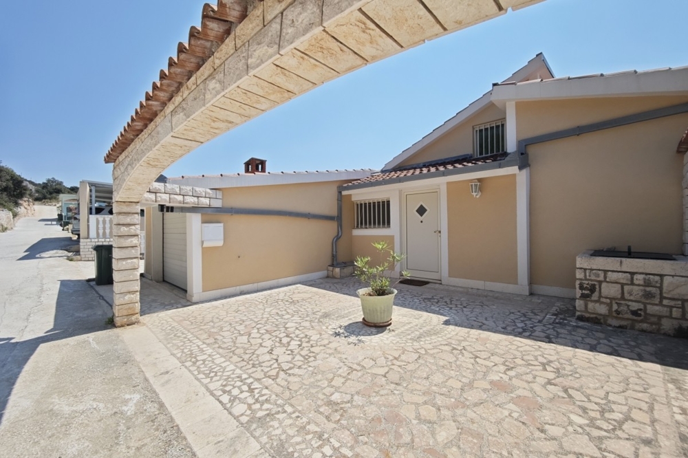 Házhomlokzat garázzsal és aszfaltozott udvarral