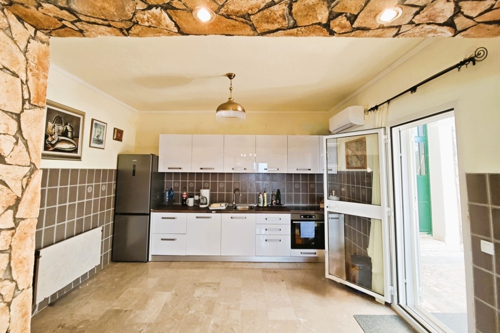 Konyha-nappali felszerelt konyhával és kijárattal a teraszra