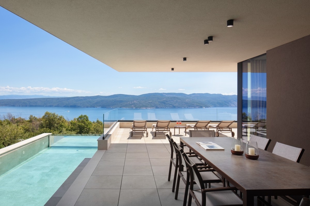 Fedett terasz étkezővel és kilátással a tengerre