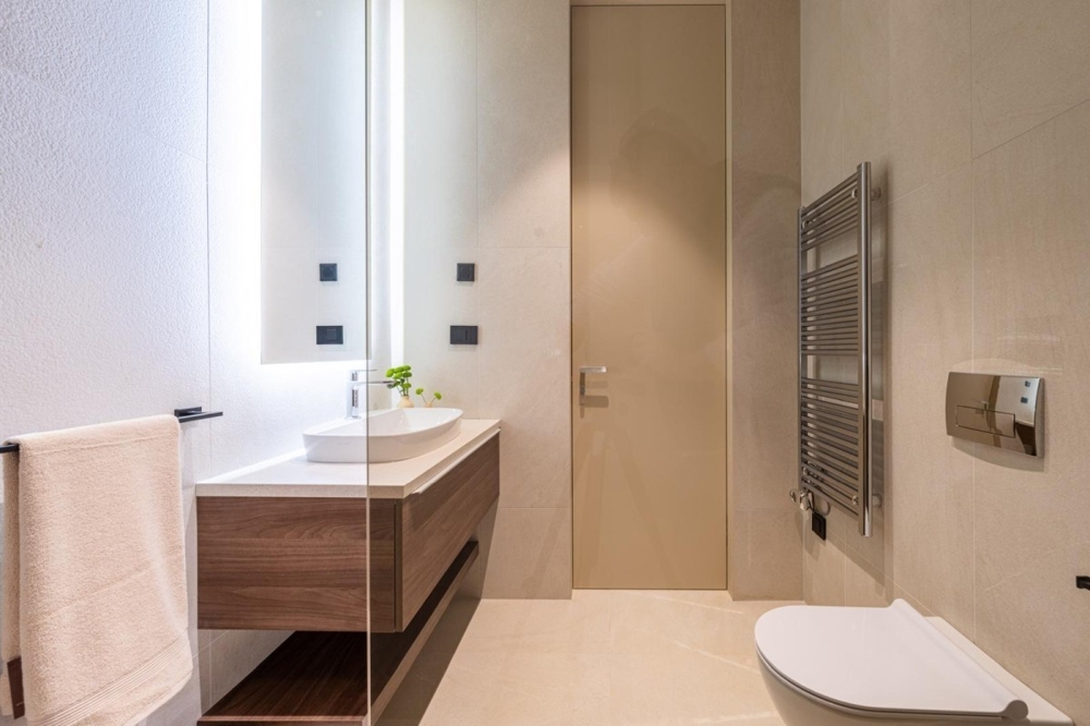 Világos fürdőszoba mosdóval és törölközőradiátorral