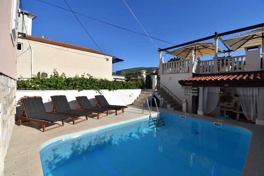 Medence napozóterasszal és nyugágyakkal