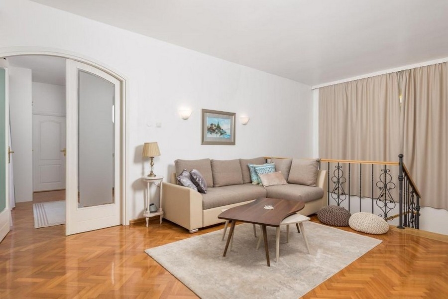 A felső szinten nappali kanapéval és parkettás padlóval