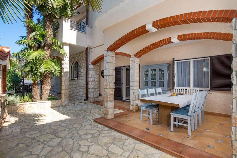 Fedett terasz ülősarokkal és természetes kőhomlokzattal