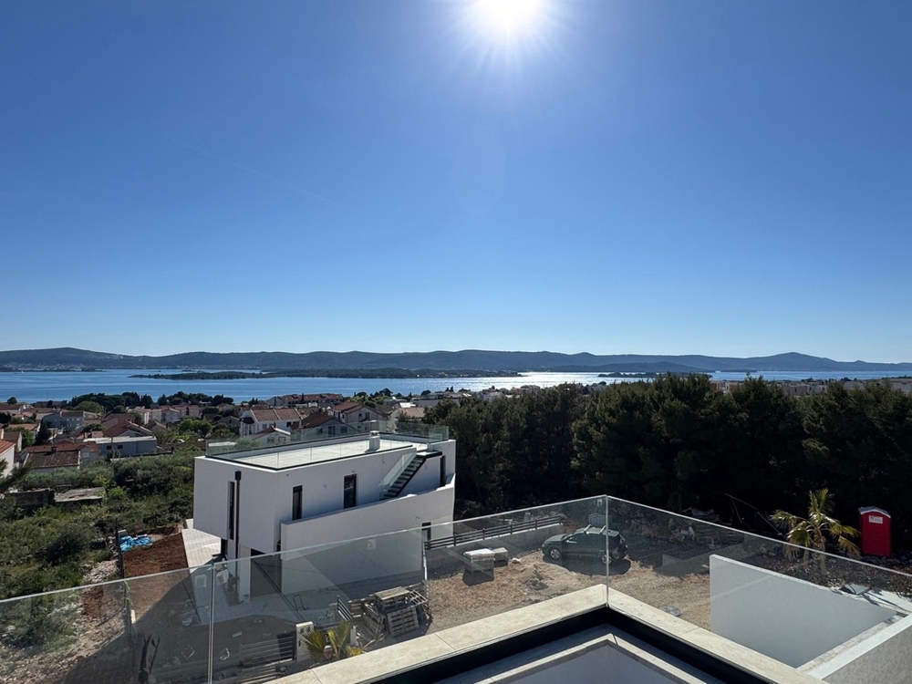 Oldalnézetből a modern villa pálmafával és kerttel