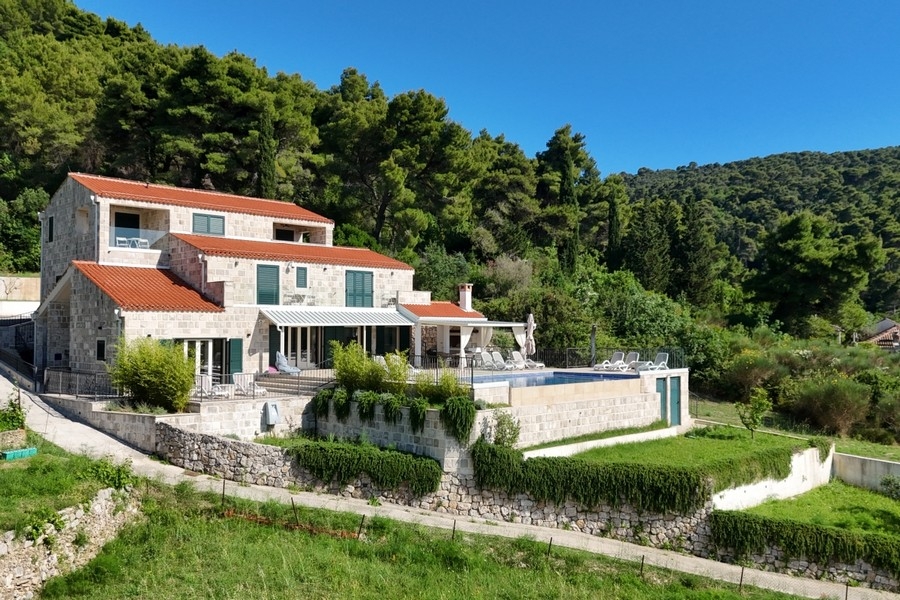 Villa kőhomlokzattal, kerttel és medencével