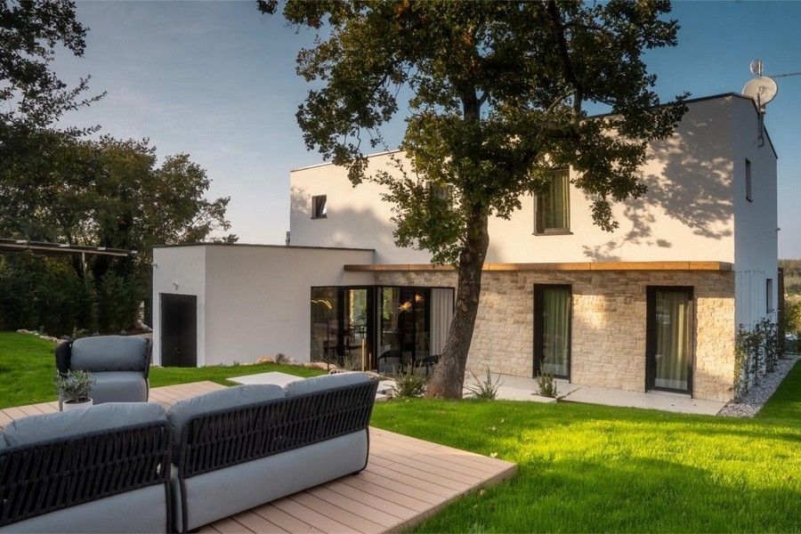 Villa kőhomlokzattal és nappalival a fa teraszon
