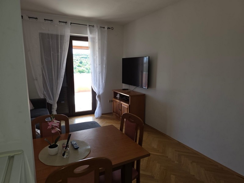 Nappali asztallal, televízióval és teraszajtóval