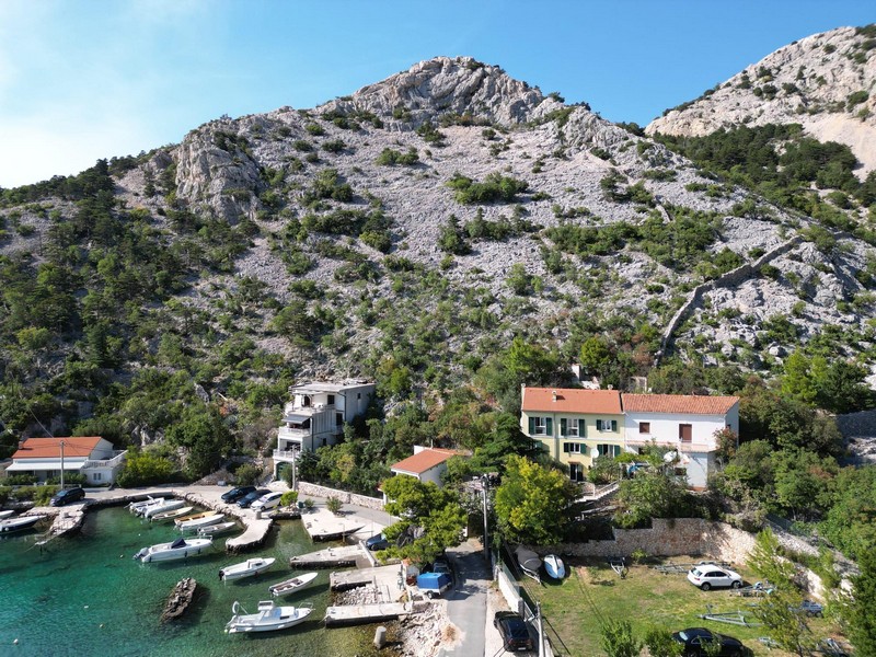 Öböl tiszta vízzel és a Velebit-hegység felülről