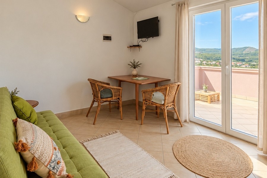 Egy apartman nappalija kanapéval és teraszajtóval