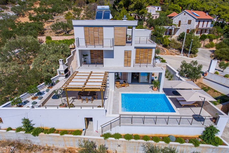 Modern villa medence terasszal egy domboldalon