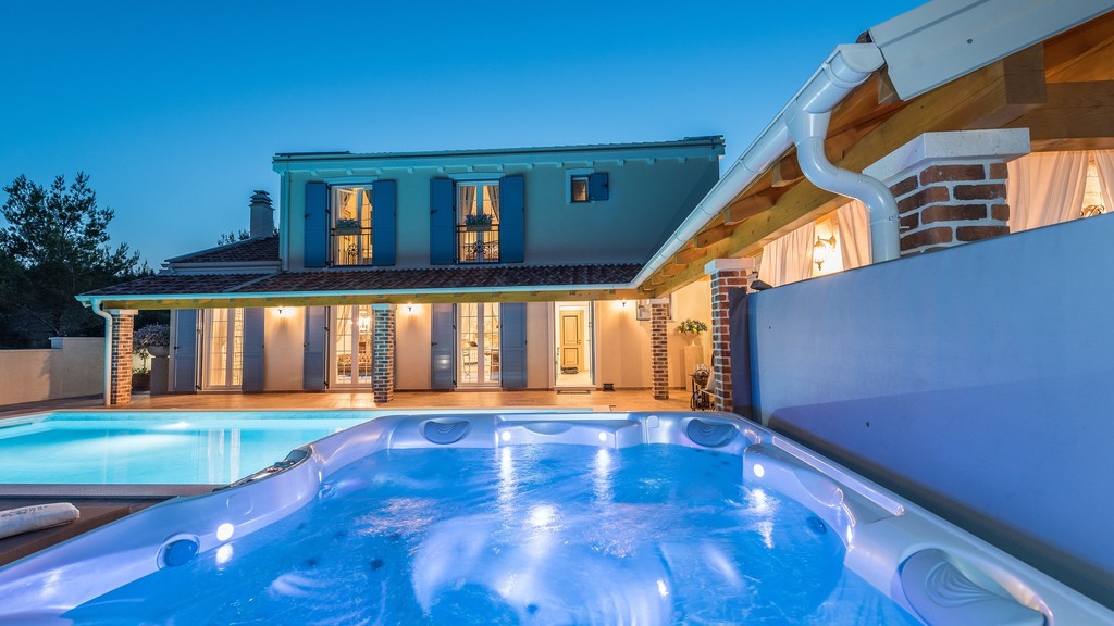 Megvilágított medence és jacuzzi esti fényben