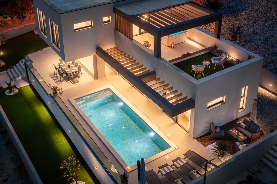 A villa és a medence felülnézetből, esti fényben