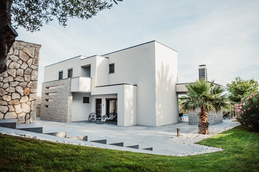 Modern villa gyeppel és kőhomlokzattal