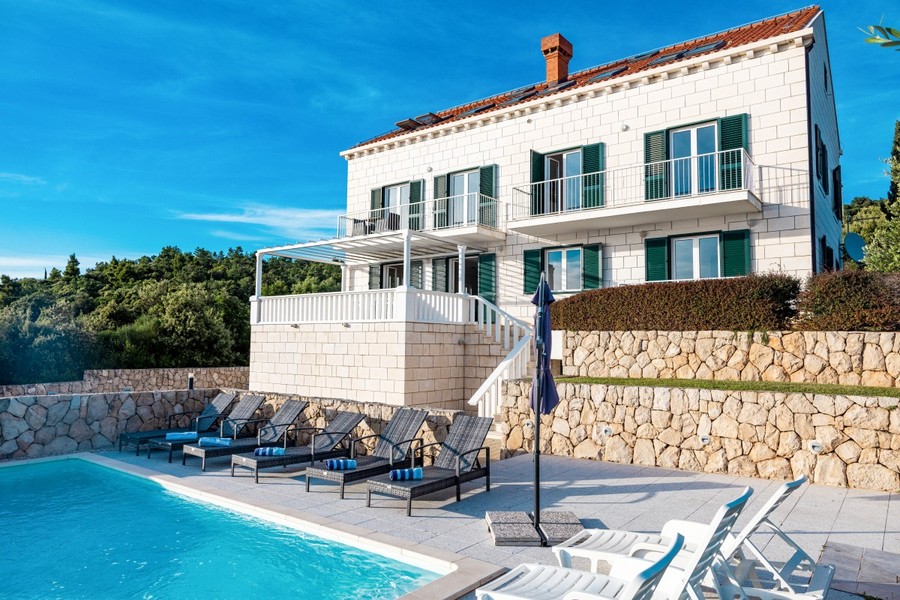Kőből épült villa medencével és napozóágyakkal