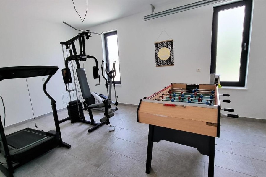 Helyiség fitneszgépekkel és csocsóasztallal