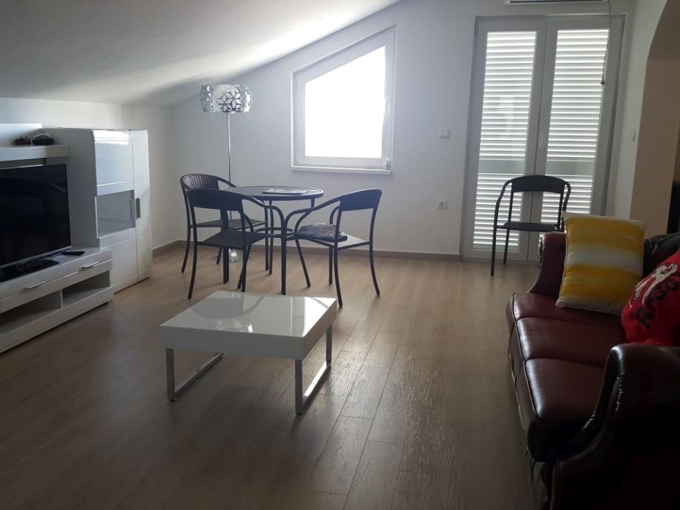 Az eladó apartmanvilla egyik felújított nappalija konyhával